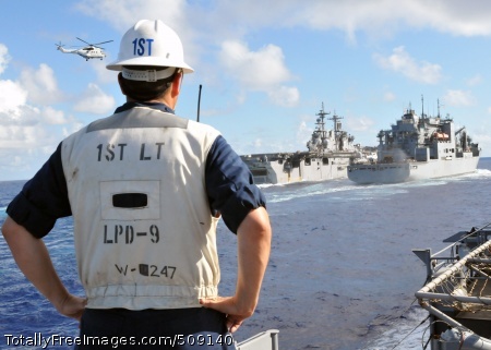 101002-N-8113T-047
PACIFIC OCEAN (Oct. 2, 2010) An officer watches the Wasp-class amphibious assault ship USS Essex (LHD 2), left, conduct a vertical replenishment with the Military Sealift Command dry cargo and ammunition ship USNS Alan Shepard (T-AKE 3). Essex is the flagship for the permanently forward-deployed Essex Amphibious Ready Group and is underway for a scheduled patrol in the western Pacific Ocean. (U.S. Navy photo by Mass Communication Specialist 1st Class N. Ross Taylor/Released)